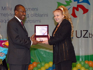 Генеральный секретарь Международного союза электросвязи Хамадун Туре вручает награду Алене Палевой
